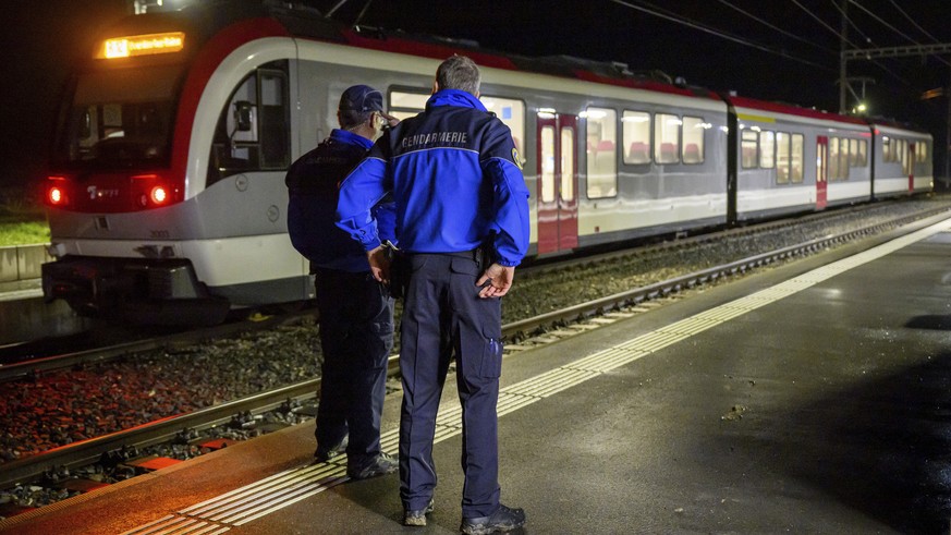Vaud cantonal police officers watch the Travys train where a hostage-taking incident took place at Essert-sous-Champvent station, Switzerland, Thursday, Feb. 8, 2024. A hostage-taking incident took pl ...