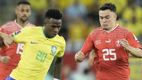 Brazil&#039;s Vinicius Junior, centre, challenges for the ball with Switzerland&#039;s Remo Freuler, left, and Fabian Rieder during the World Cup group G soccer match between Brazil and Switzerland at ...