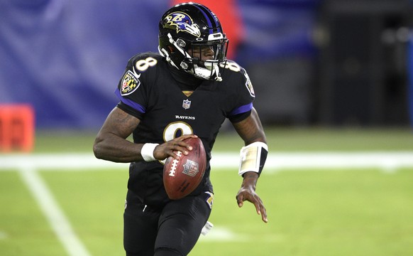 Baltimore Ravens quarterback Lamar Jackson rolls out against the Dallas Cowboys during the first half of an NFL football game, Tuesday, Dec. 8, 2020, in Baltimore. (AP Photo/Nick Wass)