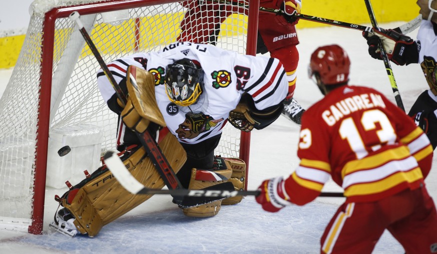 Chicago Blackhawks&#039; goalie Marc-Andre Fleury, left, lets in a goal as Calgary Flames&#039; Johnny Gaudreau watches during the third period of an NHL hockey game Tuesday, Nov. 23, 2021, in Calgary ...