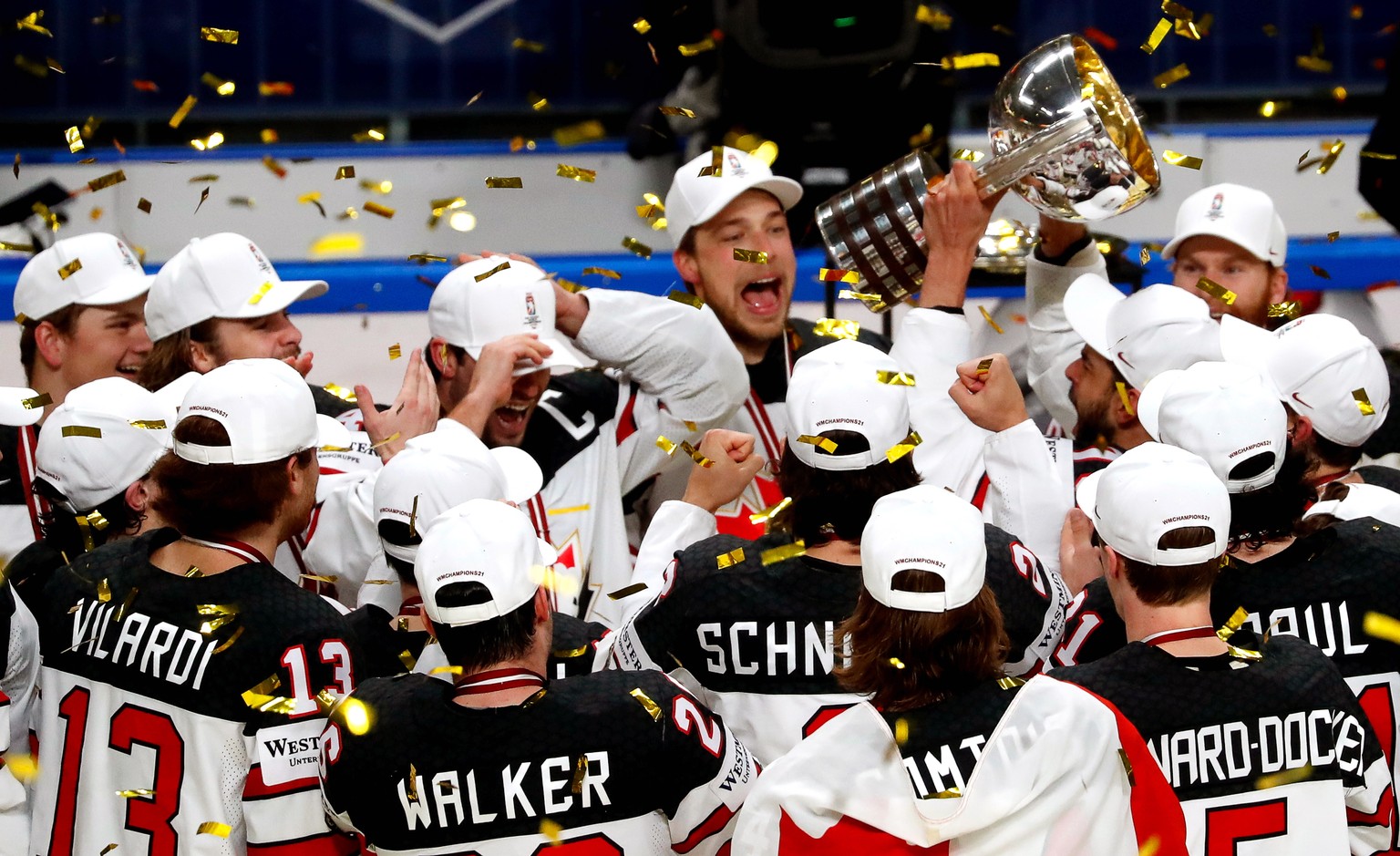 epa09252138 Players of Canada celebrate with the trophy after winning the IIHF Ice Hockey World Championship 2021 final match between Finland and Canada at the Arena Riga, Latvia, 06 June 2021. EPA/TO ...