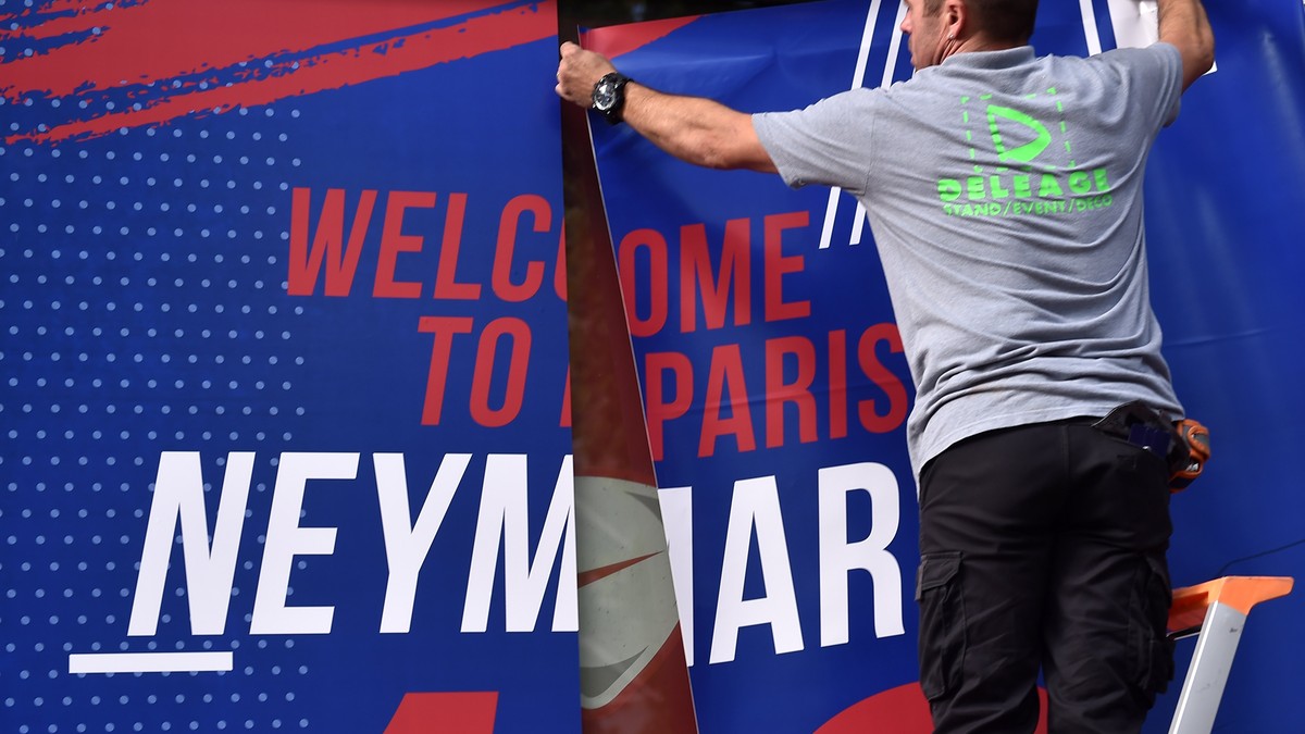 epa06124025 Staff members display a billboard reading 'Welcome to Paris Neymar Jr 10' on the facade of the official Paris Saint-Germain (PSG) store on the Champs Elysee avenue in Paris, Fran ...