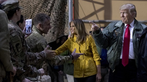President Donald Trump and first lady Melania Trump greet members of the military as they arrive for a hanger rally at Al Asad Air Base, Iraq, Wednesday, Dec. 26, 2018. In a surprise trip to Iraq, Pre ...