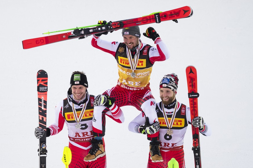 Michael Matt of Austria, left, silver medal, Marcel Hirscher of Austria, center, gold medal, Marco Schwarz of Austria, right, bronze medal, celebrate during the medals ceremony after the second run of ...
