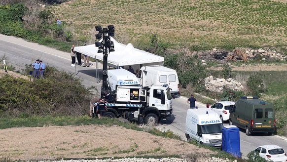 epa06270694 Malta Police officers stand by the scene where a prominent blogger in Malta, Daphne Caruana Galizia, died in a car bomb attack IN Bidnija, Malta, 17 October 2017. Caruana Galizia, 53, was  ...