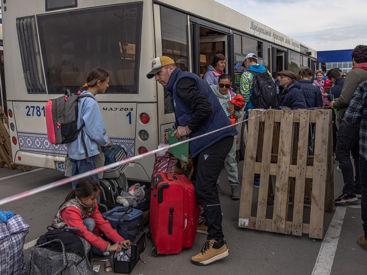 epa09924728 People evacuated from the steel plant Azovstal, Mariupol city and the surrounding areas gather after arriving on buses in Zaporizhzhia, Ukraine, 03 May 2022. Around 100 civilians were evac ...