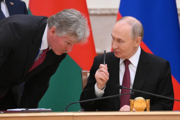 Kremlin spokesman Dmitry Peskov, left, listens to Russian President Vladimir Putin during a signing ceremony following a meeting of the Supreme State Council of the Russia-Belarus Union State marking  ...