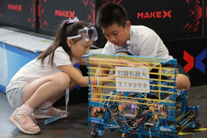 epa06157236 Chinese competitors adjust their robot ahead of a robot competition of the 2017 World Robot conference in Beijing, China, 23 August 2017. The conference is held from 23 to 27 August, inclu ...