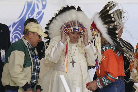 Pope Francis dons a headdress during a visit with Indigenous peoples at Maskwaci, the former Ermineskin Residential School, Monday, July 25, 2022, in Maskwacis, Alberta. Pope Francis traveled to Canad ...