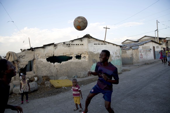 In this Feb. 11, 2020 photo, youths play soccer in the Cite Soleil slum of Port-au-Prince, Haiti. Haiti&#039;s economy appears to be shrinking and electricity comes only a few hours a day in most of t ...