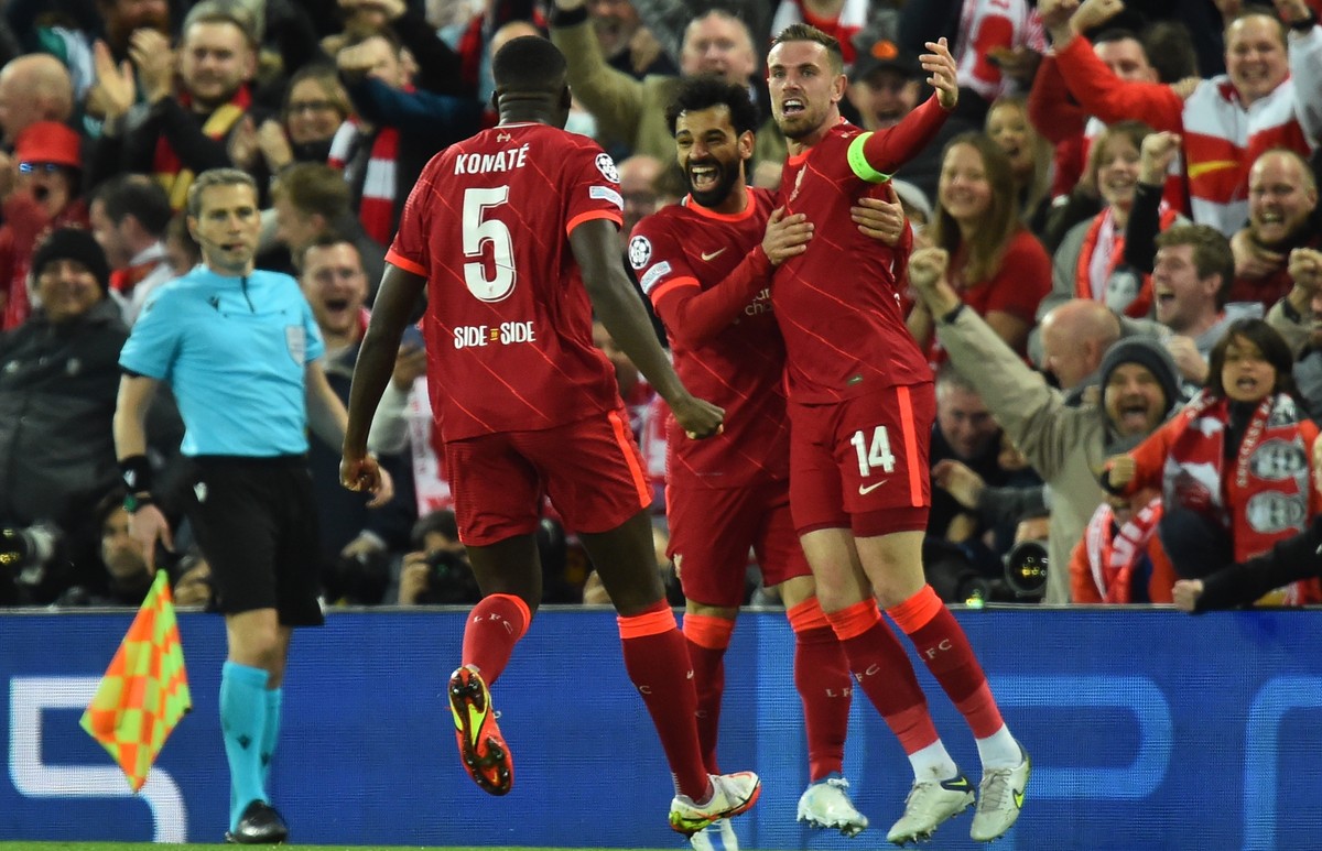 epa09913046 Liverpool's Jordan Henderson (R), Mohamed Salah (C) and Ibrahima Konate (L) celebrate the 1-0 lead during the UEFA Champions League semi final, first leg soccer match between Liverpoo ...