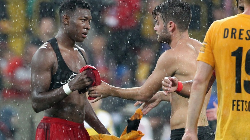 DRESDEN, GERMANY - AUGUST 17: Niklas Kreuzer of Dresden and David Alaba of Bayern Muenchen change the shirts after the friendly match between SG Dynamo Dresden and FC Bayern Muenchen at Gluecksgas-Sta ...