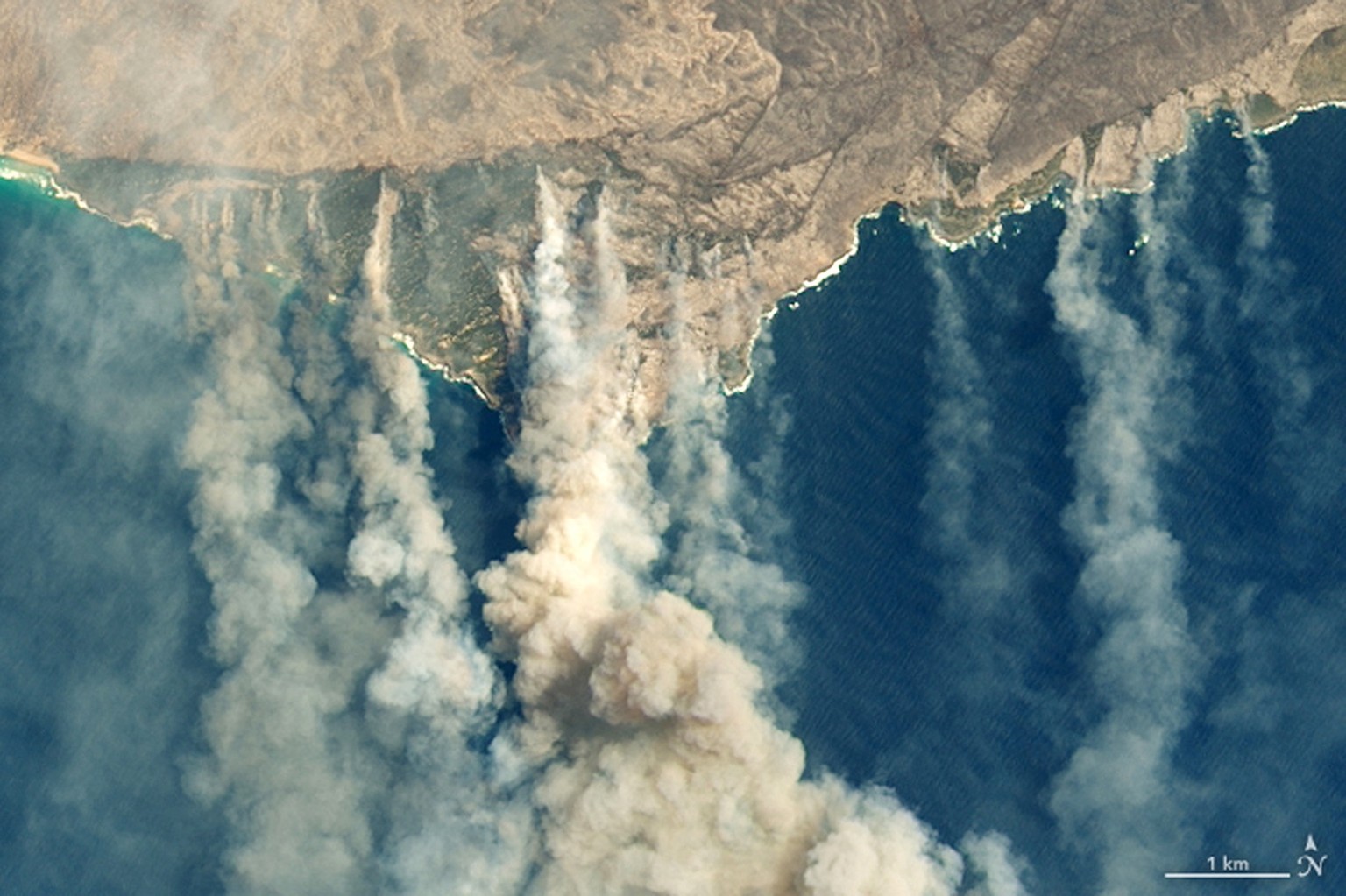 epa08115966 A handout photo made available by NASA Earth Observatory of a satellite image showing burned land and thick smoke over Kangaroo Island, Australia, 09 January 20202 (issued 10 January 2020) ...