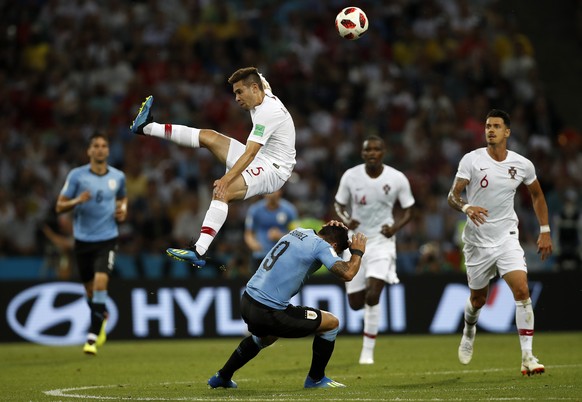 Portugal&#039;s Raphael Guerreiro, up, and Uruguay&#039;s Luis Suarez challenge for the ball during the round of 16 match between Uruguay and Portugal at the 2018 soccer World Cup at the Fisht Stadium ...