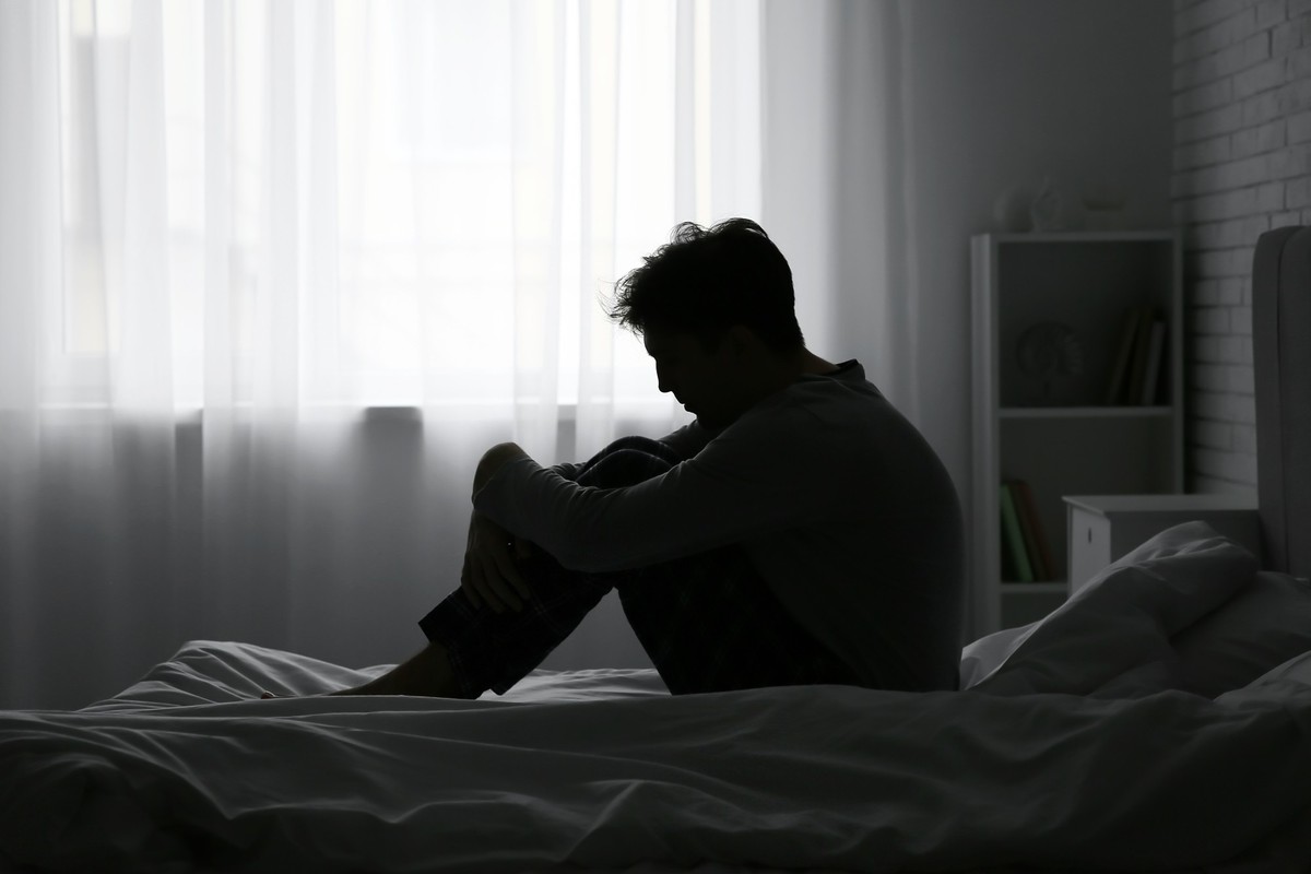 junger erwachsener, depressiv in seinem zimmer