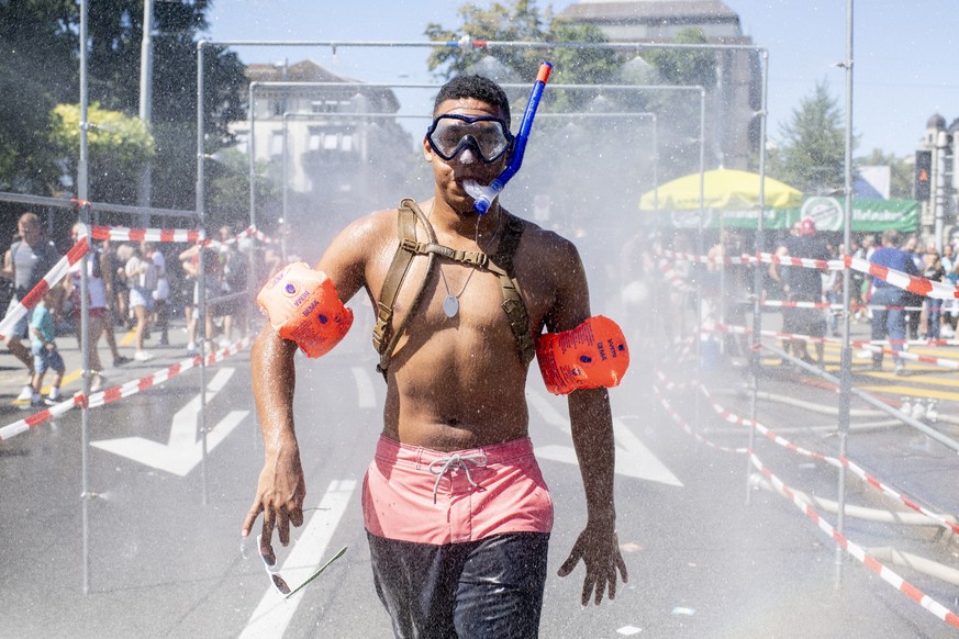 epa06943164 A participant cools himself during the 27th Street Parade, an annual dance music parade, in the city center of Zurich, Switzerland, 11 August 2018. The annual dance music event Street Para ...