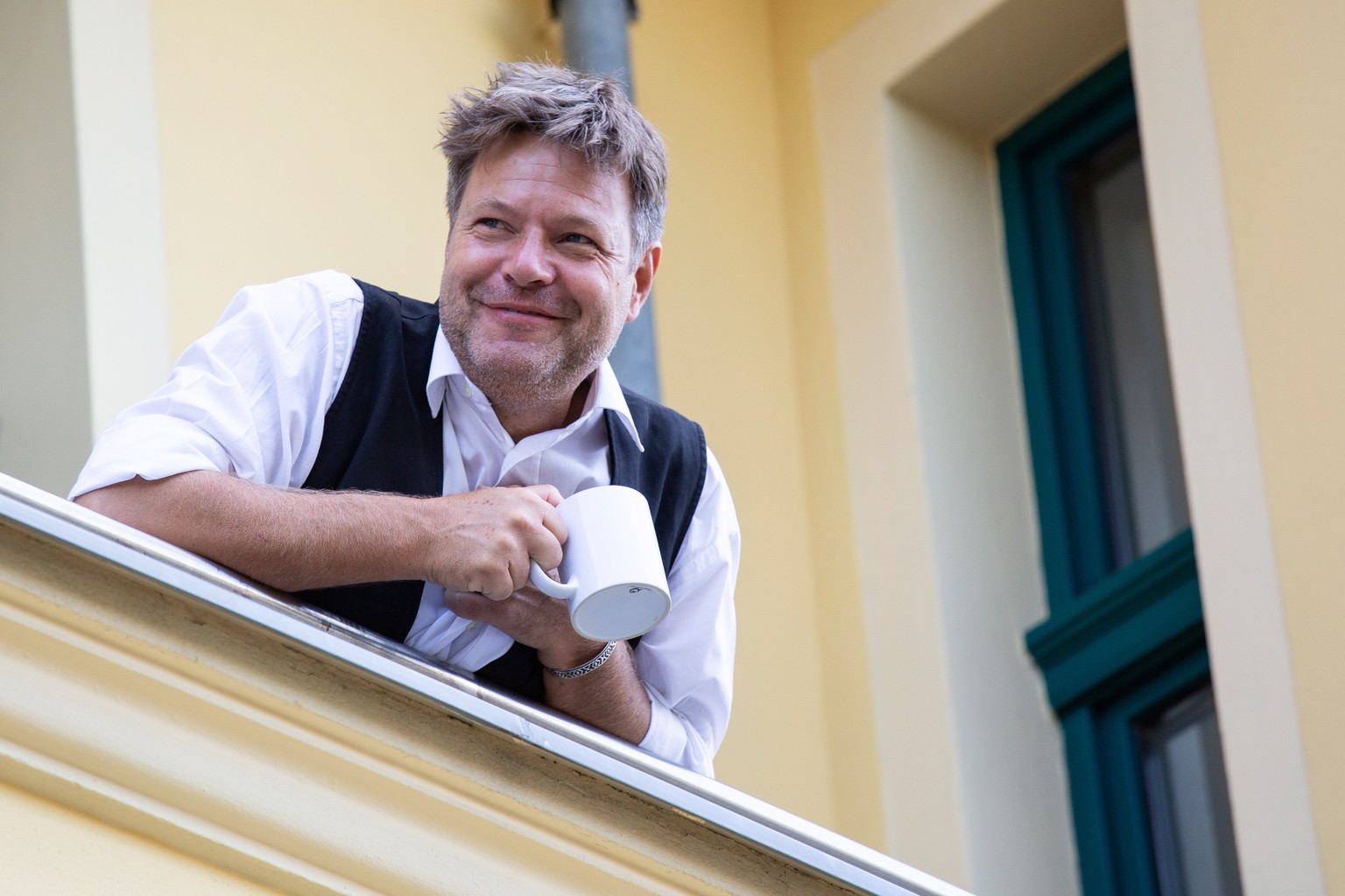 epa07769456 Co-Chairman of the German Greens party Robert Habeck is seen standing in the balcony of the Alliance 90/The Greens party headquarters, prior to the opening of the board meeting of the fede ...