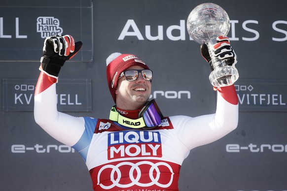 Switzerland&#039;s Beat Feuz holds up the alpine ski, men&#039;s World Cup downhill trophy, in Kvitfjell, Norway, Saturday, March 7, 2020. (AP Photo/Gabriele Facciotti)