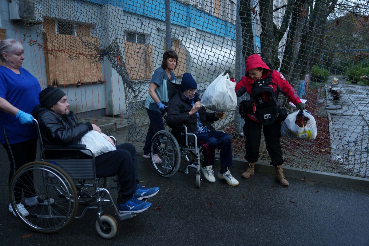 Nurses and Red Cross volunteer move men on wheelchairs into an ambulance during an evacuation to a safe area amid a local ceasefire linked to a humanitarian aid mission in Oleshky, in Ukraine's K ...