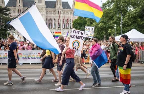 epa10696580 A woman displays a banner reading &#039;Putin go homo&#039; as she attend the Rainbow Parade in Vienna, Austria, 17 June 2023. The Rainbow Parade, a rally against the discrimination of les ...