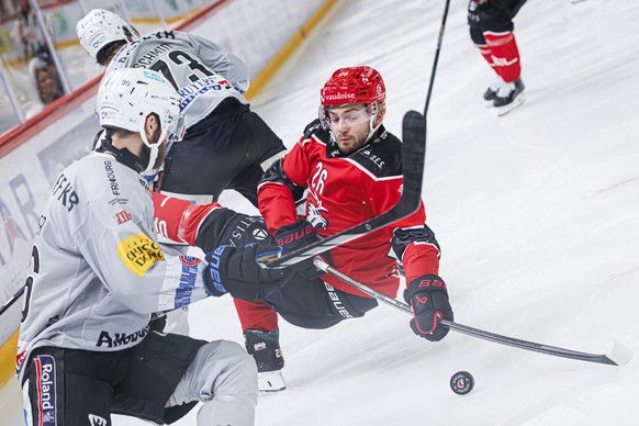 Andrea Glauser (HCFG), gauche, lutte pour le puck avec Erik Brannstroem (LHC), droite, lors du match du championnat suisse de hockey sur glace de National League entre Lausanne HC, LHC, et le HC Fribo ...