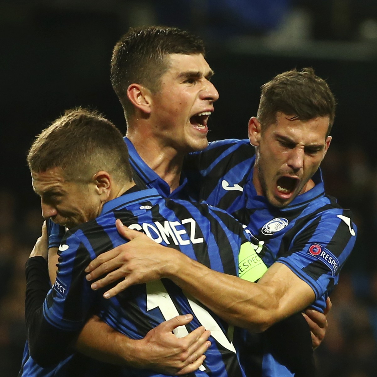 Atalanta's Ruslan Malinovskyi, center, celebrates with his teammates Papu Gomez, left, Remo Freuler after scoring on a penalty kick his side's first goal, during the group C Champions League ...