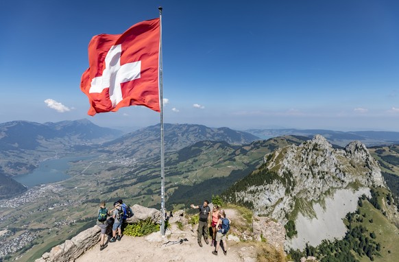 Wanderer auf dem Grossen Mythen oberhalb von Brunni stehen unter einer Schweizer Fahne am Samstag, 4. August 2018. Bis zu 40'000 Menschen wandern jedes Jahr auf den Berg. Auch auf 1898 Meter uebe ...