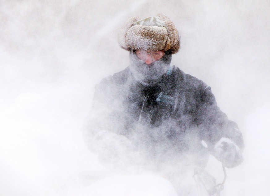 Garret Kelenske, 49, works to remove snow on the sidewalk along Hoyt Street near Sacred Heart Church in Muskegon Heights, Mich., Tuesday, Jan. 7, 2014. He is the facility maintenance manager for the c ...