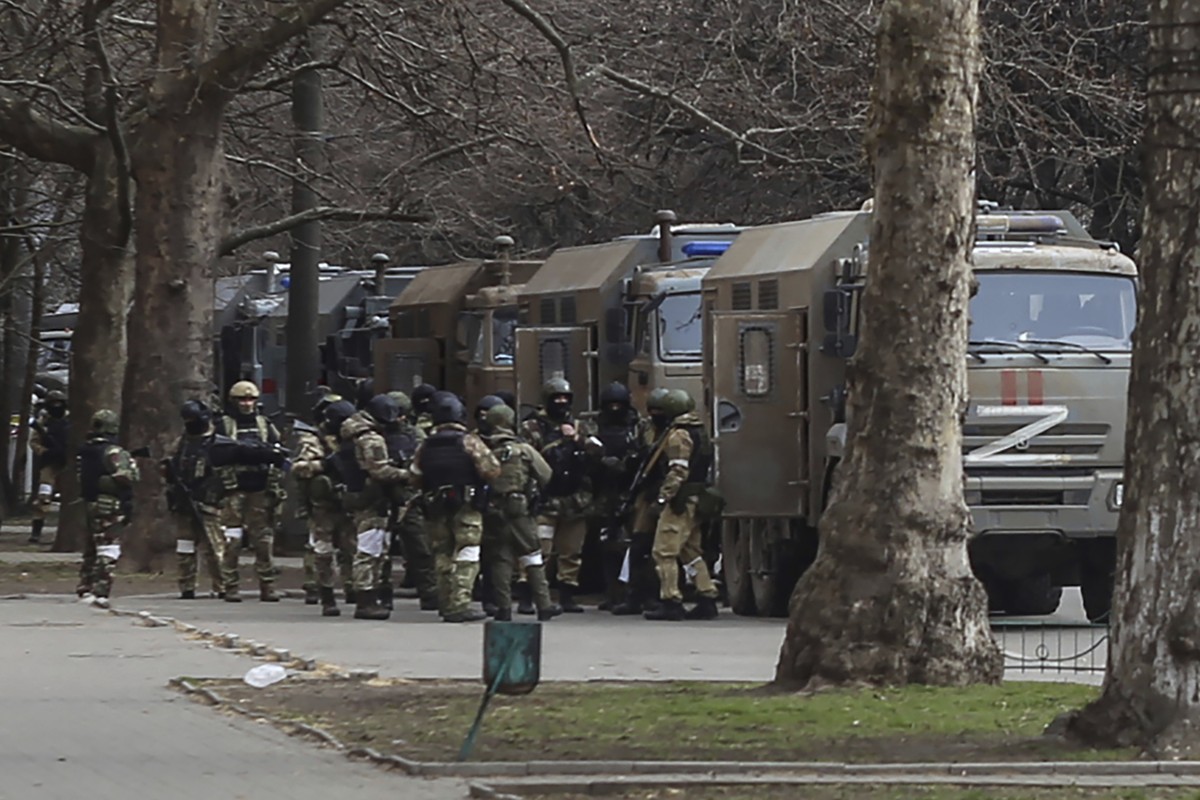 FILE - Russian army soldiers stand next to their trucks during a rally against Russian occupation in Svobody (Freedom) Square in Kherson, Ukraine, Monday, March 7, 2022. Russia