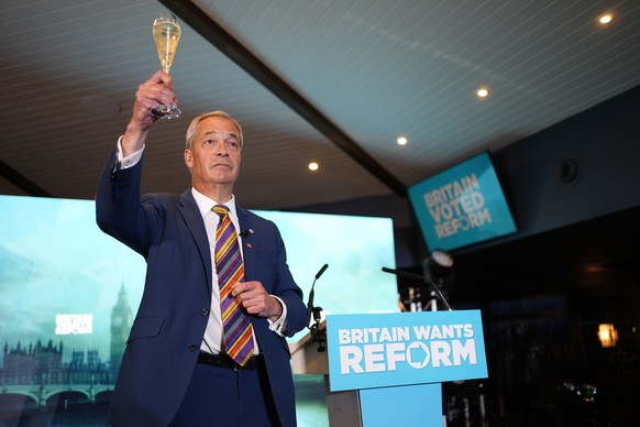 Reform UK leader Nigel Farage offers a toast as he speaks to supporters at Chelmsford City Racecourse, Friday May 8, 2026, in Essex, England, following the 2026 local election results. (Jordan Pettitt ...