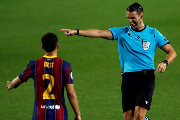 epa08760382 Swiss referee Sandro Schaerer (R) calls for a penalty during the UEFA Champions League Group G soccer match between FC Barcelona and Ferencvaros held at Camp Nou stadium, in Barcelona, Spa ...