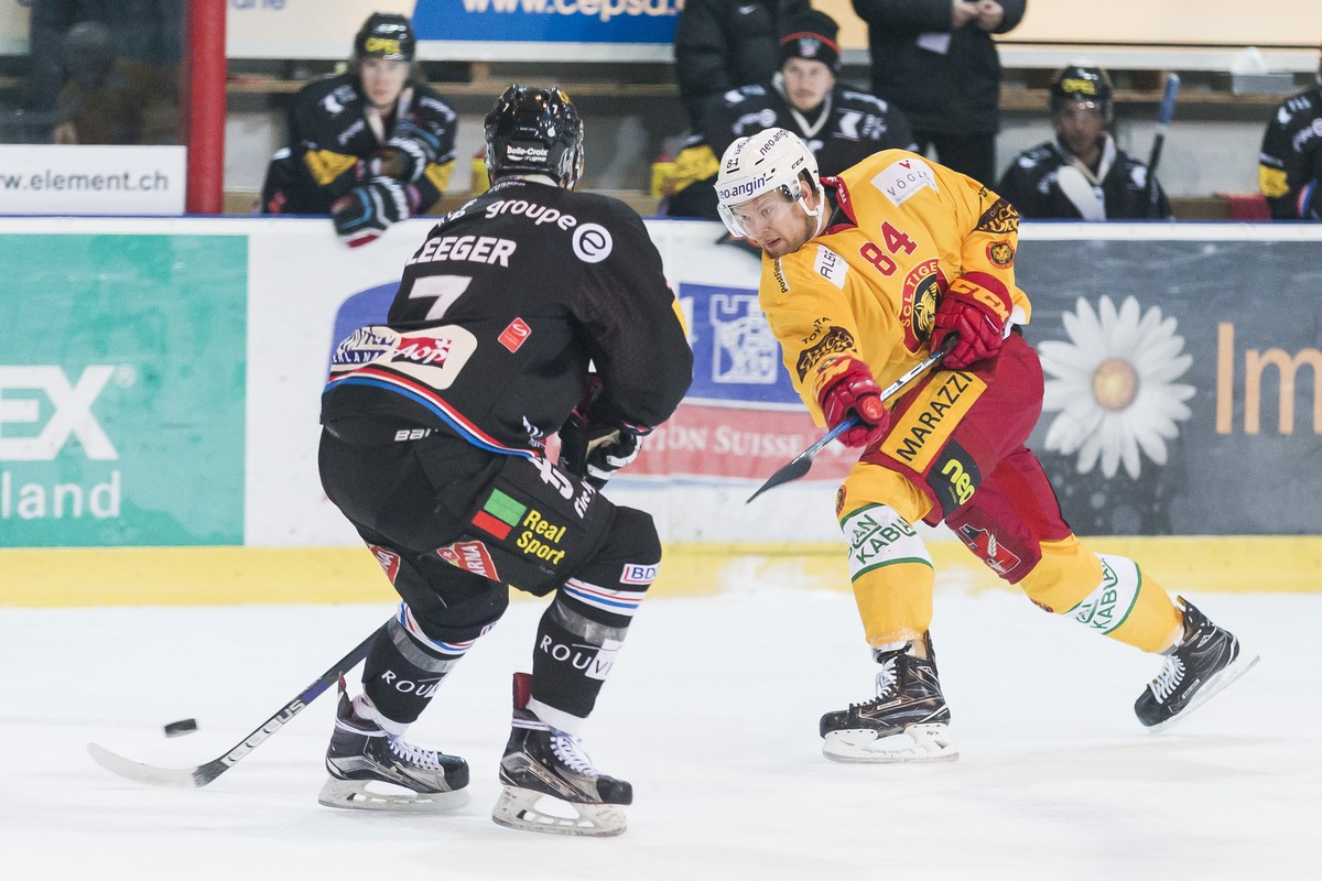 Le defenseur fribourgeois Larri Leeger, gauche, lutte pour le puck avec l'attaquant de Langnau Elo Eero, droite, lors du match du championnat suisse de hockey sur glace de National League A entre ...