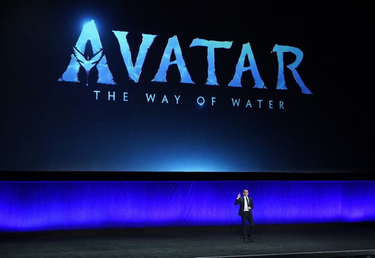 Tony Chambers, executive vice president of theatrical distribution for Walt Disney Studios, speaks underneath a graphic for the upcoming film "Avatar: The Way of Water" during the Walt Disne ...