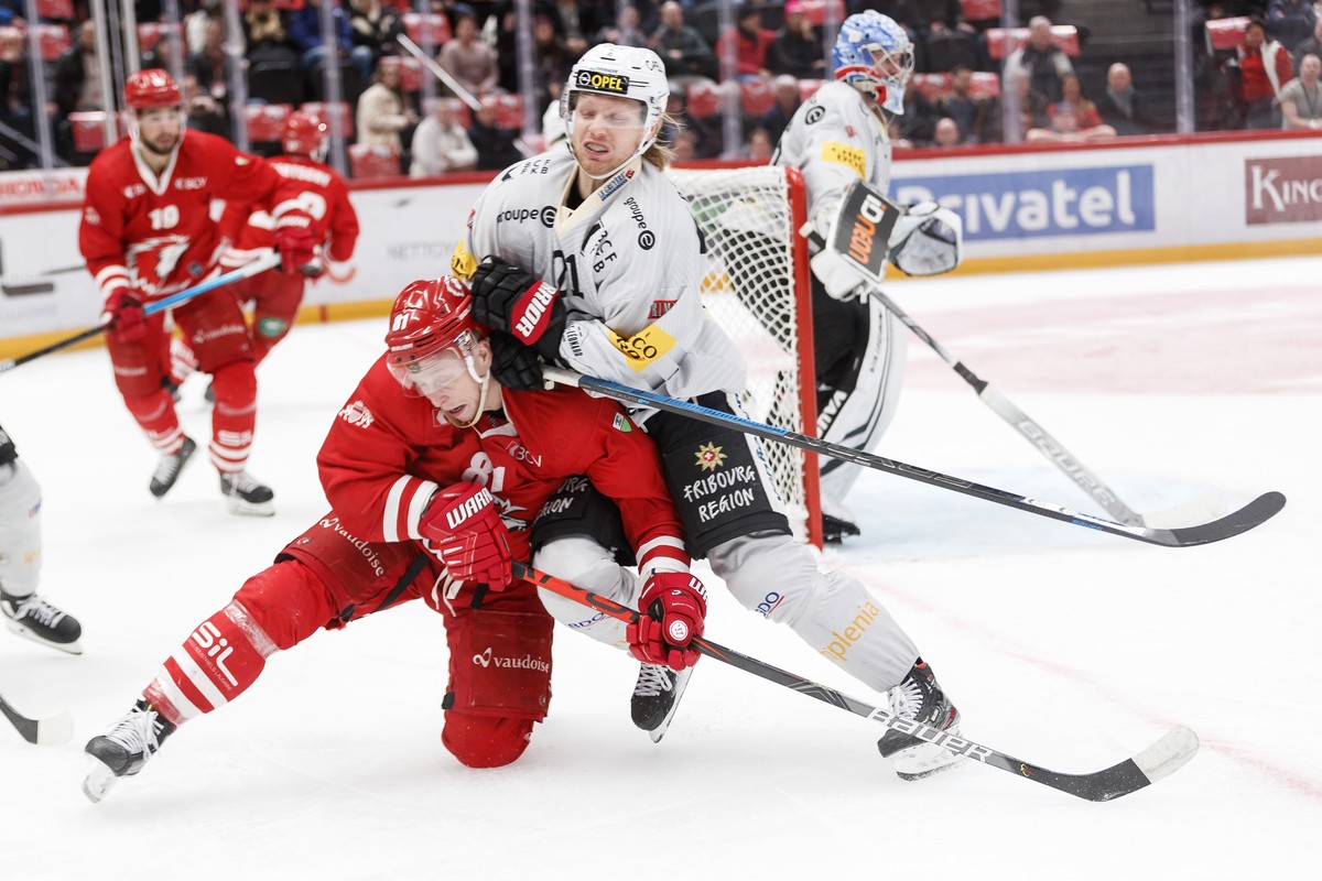 L'attaquant lausannois Ronalds Kenins, gauche, lutte pour le puck avec l'attaquant fribourgeois Flavio Schmutz, droite, lors de la rencontre du championnat suisse de hockey sur glace de Nati ...