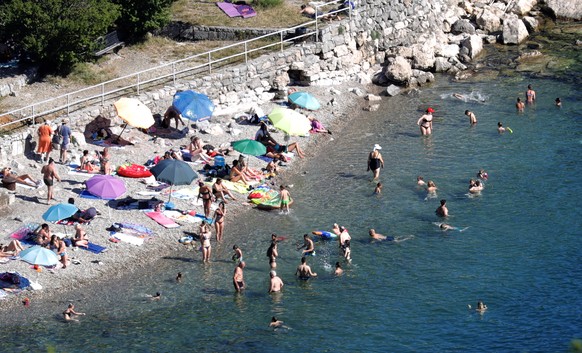 epa08518607 Foreign tourists bask in the sun at a beach in the town of Opatija, Croatia, 30 June 2020. Croatia has reopened its borders to visitors from abroad following months of closure due to the o ...