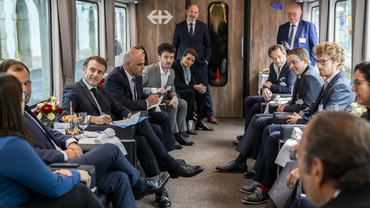 French President Emmanuel Macron, left, and Swiss President Alain Berset, right, speak during a discussion with start-up representatives, on board the special train, Switzerland, Thursday, 16 November ...