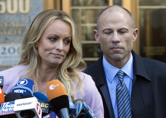FILE - In this April 16, 2018 file photo, adult film actress Stormy Daniels, left, stands with her lawyer Michael Avenatti as she speaks outside federal court, in New York. The Justice Department says ...