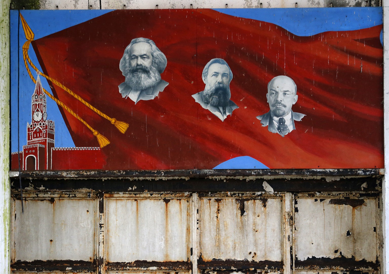 In this photo taken Friday, Nov. 7, 2014, a mural depicting Communist icons, from left, Karl Marx, Friedrich Engels and Vladimir Lenin hangs on a wall of a bomb assembly and repair facility in an aban ...