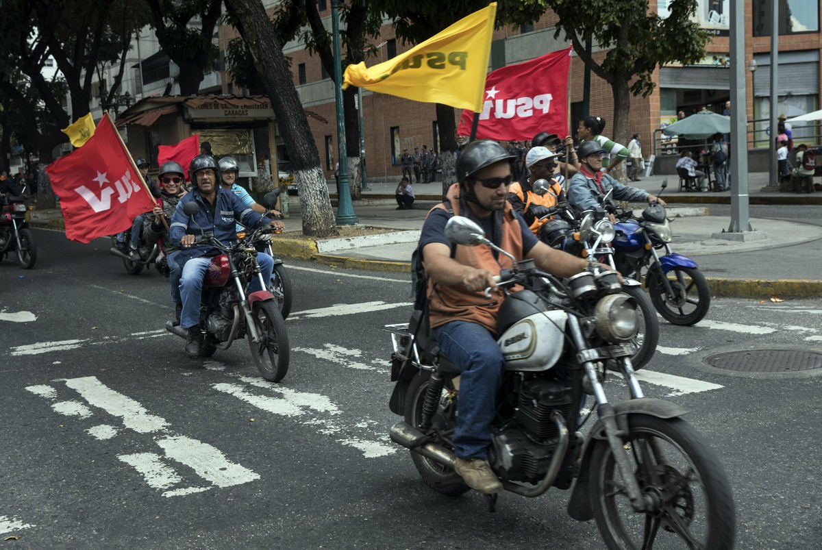 Supporters of President Nicolas Maduro known as "Colectivos", parade in on their motorbikes while anti=government supporters take part in a walkout against Maduro, in Caracas, Wednesday, Jan ...