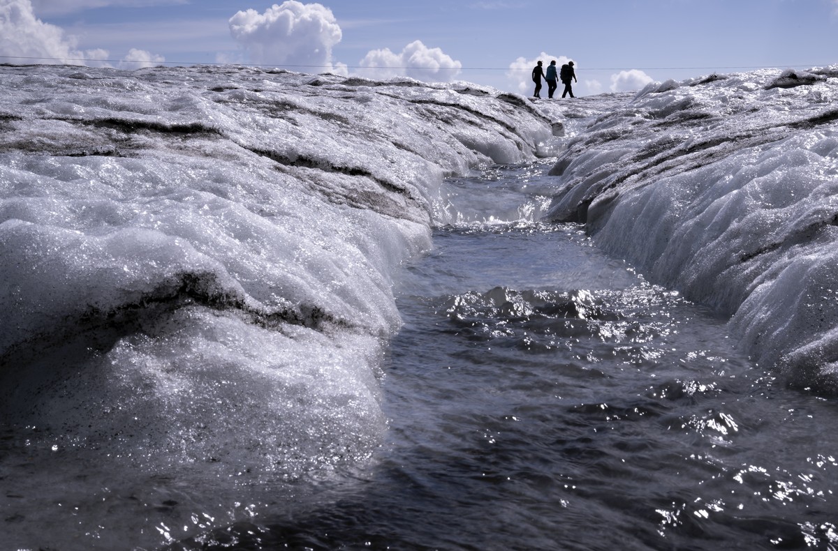 People walk on the Tsanfleuron Glacier at the "Glacier 3000" alpine resort, above Les Diablerets, Switzerland, Saturday, August 6, 2022. The Swiss Glacier Monitoring Switzerland (GLAMOS), fe ...