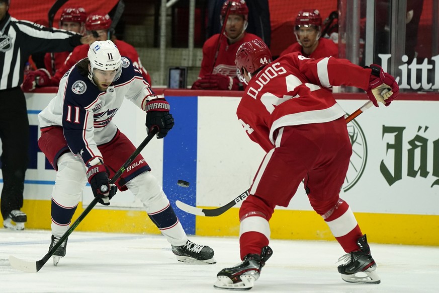Detroit Red Wings defenseman Christian Djoos (44) passes the puck away form Columbus Blue Jackets center Kevin Stenlund (11) during the third period of an NHL hockey game, Sunday, March 28, 2021, in D ...