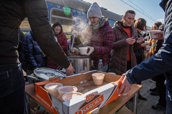 epaselect epa09792054 Volunteers provide food aid to Ukrainians fleeing from Kiev to Warsaw, as their train stops at the railway station in Dorohusk, Poland, 28 February 2022. The United Nations (UN) ...