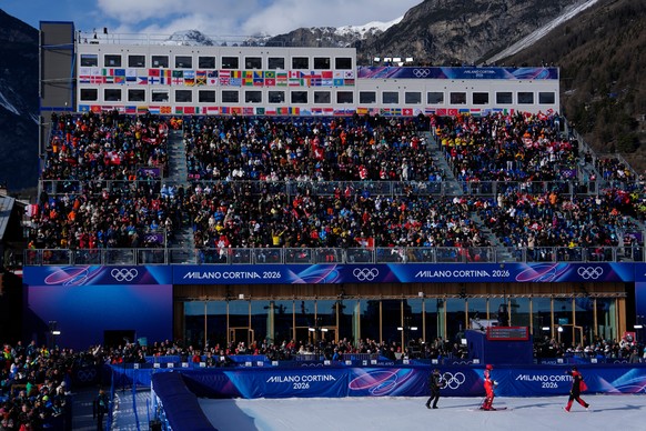Switzerland's Franjo von Allmen, right, runs to his teammate Switzerland's Tanguy Nef at the finish area of an alpine ski men's slalom portion of a team combined race, at the 2026 Winte ...