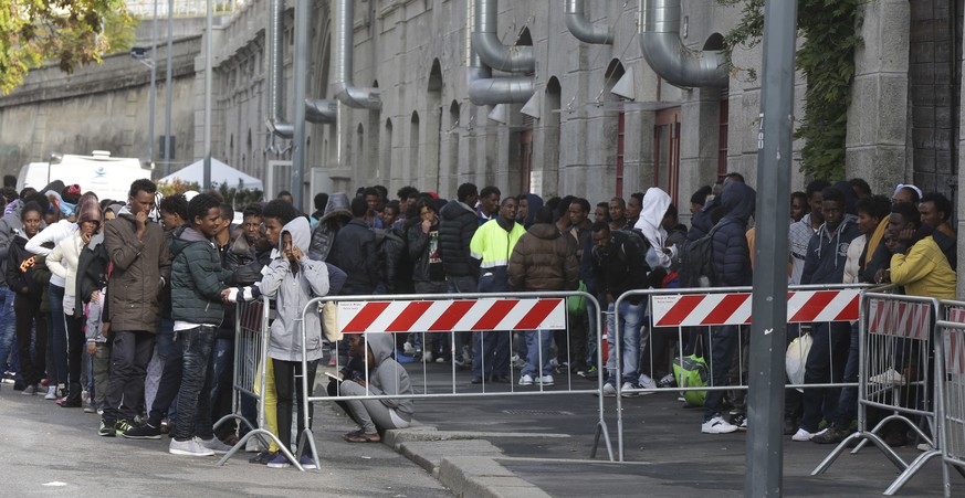 Migrants queue waiting to enter the refectory at a refugee hub in Milan, Italy, Friday, Oct. 21, 2016. About 500 people live in this overcrowded refugee reception center, managed by &#039;Progetto Arc ...