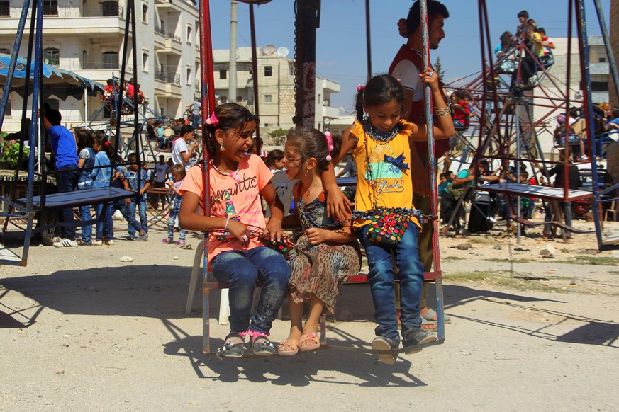 Children play on swings on the third day of Eid al-Adha in the rebel controlled city of Idlib, Syria September 14, 2016. REUTERS/Ammar Abdullah