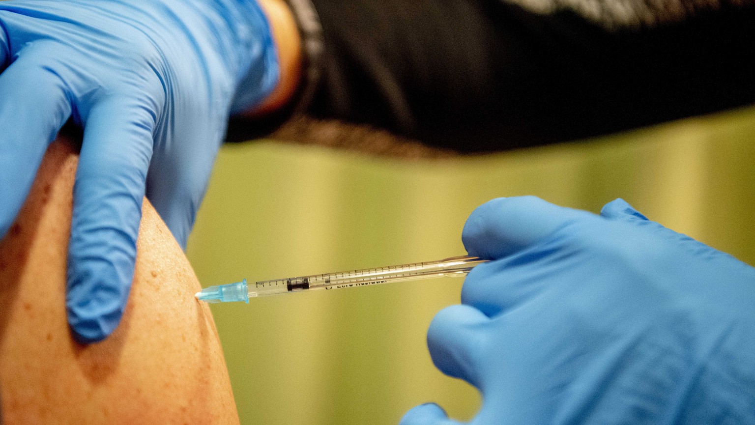 epa09605144 An employee of the Surplus care agency receives a booster shot at the Elisabeth residential care center, Breda, Netherlands, 26 November 2021. The Health Council recommends the booster vac ...