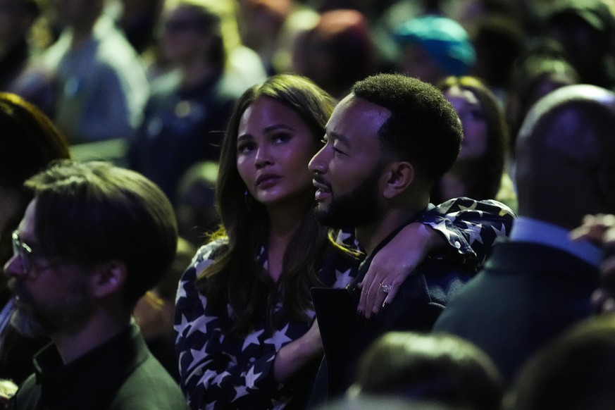 Singer John Legend, right, and his wife Chrissy Teigen listen to Bruce Springsteen perform at a campaign rally supporting Democratic presidential nominee Vice President Kamala Harris, Monday, Oct. 28, ...
