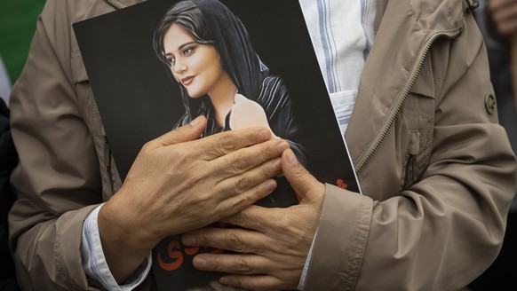 FILE - A portrait of Mahsa Amini is held during a rally calling for regime change in Iran following the death of Amini, a young woman who died after being arrested in Tehran by Iran&#039;s notorious & ...