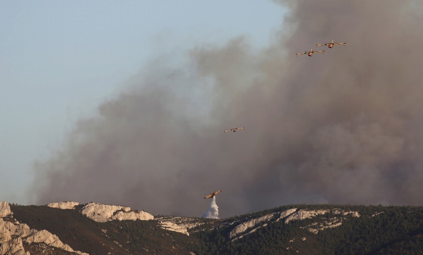 Smoke fills the sky while fire-fighting planes pour water during fires which burn the Calanques National Park near Marseille, France, September 5, 2016. REUTERS/Jean-Paul Pelissier