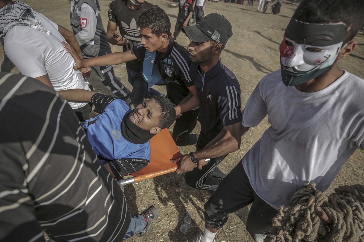 epa06728961 Palestinians carry a wounded protester during clashes after Friday protests near the border with Israel in the east of Gaza City, 11 May 2018. Reports state that one protester was killed a ...